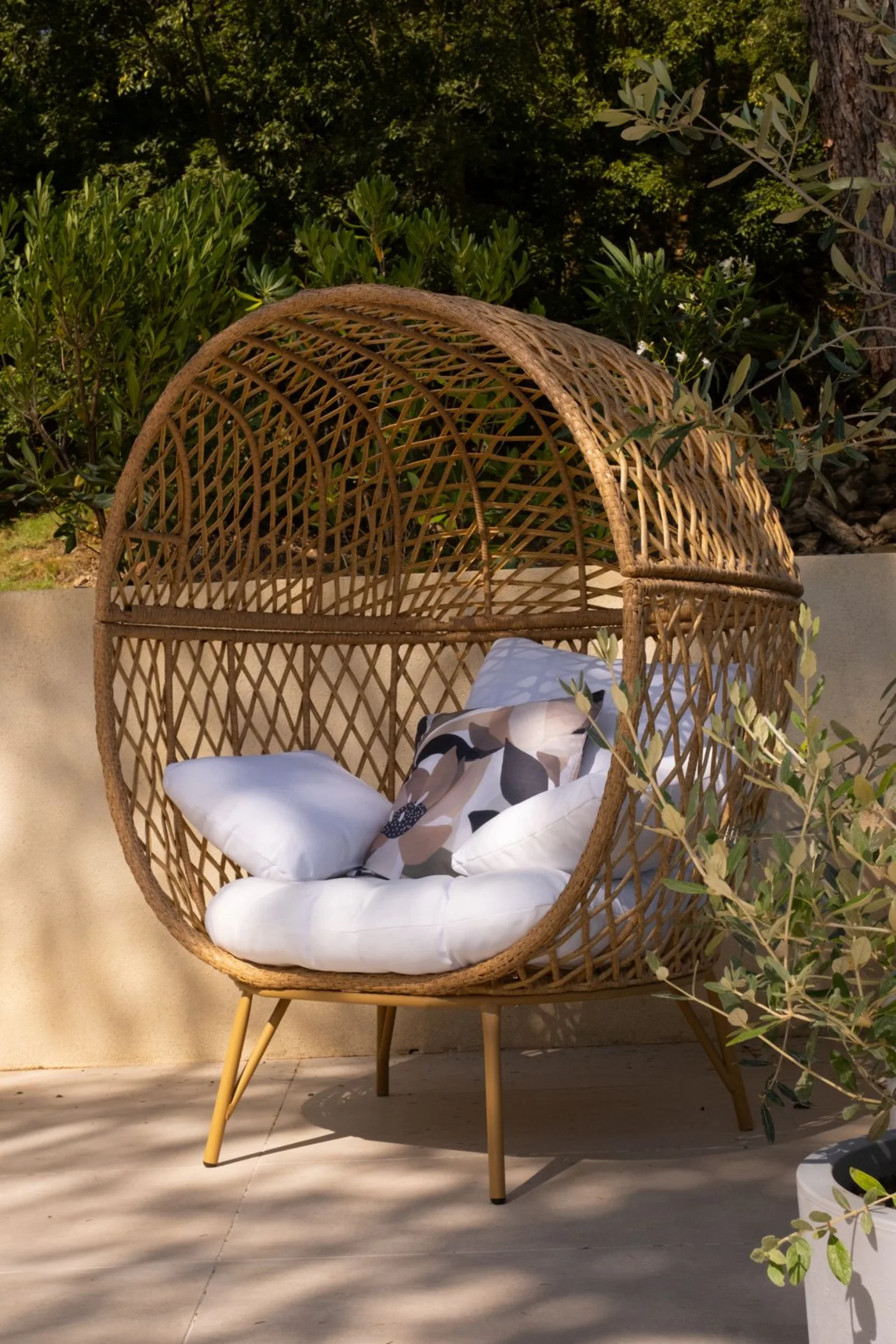 Fauteuil œuf en rotin sur la terrasse du gîte